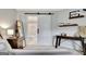 Comfortable bedroom featuring a sliding barn door to the bathroom and stylish furnishings at 505 Lighthouse Ln, Peachtree City, GA 30269
