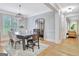 Bright dining room with a decorative light fixture, hardwood floors, and an open doorway at 505 Lighthouse Ln, Peachtree City, GA 30269