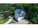 Aerial view of charming home with white siding, multiple garage doors and driveway surrounded by mature trees at 505 Lighthouse Ln, Peachtree City, GA 30269