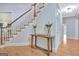 Bright foyer with hardwood floors, staircase with white risers, and a decorative console table at 505 Lighthouse Ln, Peachtree City, GA 30269