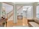 Open foyer with hardwood floors, staircase with white risers, and a view into the living room at 505 Lighthouse Ln, Peachtree City, GA 30269