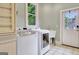 Laundry room featuring modern appliances, a sink, and access to the backyard at 505 Lighthouse Ln, Peachtree City, GA 30269