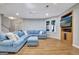 Basement living room with hardwood floors, plush blue sofa, entertainment center, and natural light at 505 Lighthouse Ln, Peachtree City, GA 30269