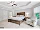 Bright main bedroom with tray ceilings, chair, nightstand, windows and carpet at 505 Lighthouse Ln, Peachtree City, GA 30269