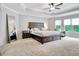 Large main bedroom features a tray ceiling, ceiling fan, carpet flooring, and an oversized mirror at 505 Lighthouse Ln, Peachtree City, GA 30269