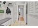 Mudroom featuring white wainscoting, coat hooks, storage bench and view to hardwood hallway at 505 Lighthouse Ln, Peachtree City, GA 30269