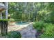 Lush backyard featuring a tranquil pool surrounded by greenery and a stone patio at 505 Lighthouse Ln, Peachtree City, GA 30269