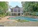 A view of the pool with a small waterfall and a screened-in porch in the background at 505 Lighthouse Ln, Peachtree City, GA 30269