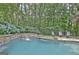 Scenic view of the pool featuring a charming waterfall and lush greenery backdrop at 505 Lighthouse Ln, Peachtree City, GA 30269