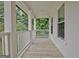 Covered porch with white railing and wood flooring surrounded by lush greenery at 505 Lighthouse Ln, Peachtree City, GA 30269