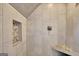 Close-up of the shower showcasing custom tile, pebble stone flooring, and a built-in bench and niche at 505 Lighthouse Ln, Peachtree City, GA 30269