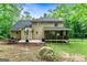 Expansive backyard with a covered porch, basketball hoop, patio, and mature trees, creating a serene setting at 135 Crimson Rdg, Tyrone, GA 30290