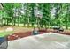 Enjoy outdoor living on the patio with a basketball hoop and grill surrounded by lush trees at 135 Crimson Rdg, Tyrone, GA 30290