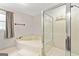 Bright bathroom featuring a soaking tub with a glass-enclosed shower and a window with natural light at 135 Crimson Rdg, Tyrone, GA 30290