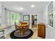 Bright dining area with wood table, window and black accent rug at 135 Crimson Rdg, Tyrone, GA 30290