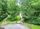 View of the long driveway leading up to the house with mature trees surrounding the property at 135 Crimson Rdg, Tyrone, GA 30290