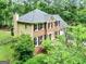 Exterior view of a brick and tan two-story home with a well manicured lawn surrounded by trees at 135 Crimson Rdg, Tyrone, GA 30290