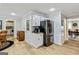 Open kitchen with stainless steel refrigerator, stone countertops, and hardwood flooring throughout at 135 Crimson Rdg, Tyrone, GA 30290