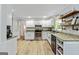 Updated kitchen featuring modern appliances, granite countertops, and white cabinetry with hardwood flooring at 135 Crimson Rdg, Tyrone, GA 30290