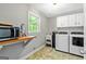 Well-lit laundry room with cabinetry, utility sink, and included washer dryer at 135 Crimson Rdg, Tyrone, GA 30290