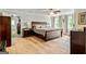 Spacious main bedroom features a wooden bed frame, hardwood floors, and a view of a walk-in closet at 135 Crimson Rdg, Tyrone, GA 30290