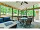 Covered porch with outdoor seating, a ceiling fan, and a view of the landscaped backyard and surrounding trees at 135 Crimson Rdg, Tyrone, GA 30290