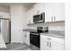 Modern kitchen with granite countertops, stainless steel appliances, and white cabinetry at 493 Prescott Way, Villa Rica, GA 30180