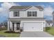 Two-story home featuring gray siding, black shutters, covered porch, and attached two-car garage at 481 Prescott Way, Villa Rica, GA 30180