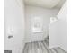 Bright foyer featuring light gray flooring, a white door with blinds, and a staircase at 481 Prescott Way, Villa Rica, GA 30180