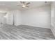 Open-concept living room with gray wood-look floors, a ceiling fan, and a large window at 481 Prescott Way, Villa Rica, GA 30180