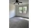 A well-lit bedroom featuring a ceiling fan, carpet flooring and a window that provides ample natural light at 121 Fountain Oak, Villa Rica, GA 30180