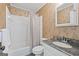 Bright bathroom with white tile shower/tub, granite countertop, and patterned wallpaper at 120 Oak Shadow Way, Fayetteville, GA 30215