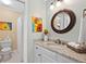 Bright bathroom featuring a granite countertop, bronze fixtures, decorative mirror, and unique sunflower accents at 120 Oak Shadow Way, Fayetteville, GA 30215