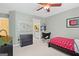 Bedroom featuring minimalist décor with a red patterned bed, black dresser, and a seating area in a bright, airy setting at 120 Oak Shadow Way, Fayetteville, GA 30215