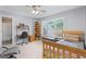 Light-filled bedroom with a ceiling fan, a wooden bed frame, and a desk next to the window for work or hobbies at 120 Oak Shadow Way, Fayetteville, GA 30215