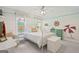 Nautical-themed bedroom featuring seaside wall decor, a white iron bed frame, and plenty of natural light at 120 Oak Shadow Way, Fayetteville, GA 30215