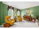 Living room area showcasing two arm chairs, a wooden piano, and green painted walls at 120 Oak Shadow Way, Fayetteville, GA 30215