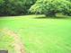 The well maintained lawn, bordered with brick, and mature trees create a serene outdoor space at 225 Long Creek Dr, Covington, GA 30016