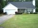 Charming single-story home featuring a well-maintained lawn, attached garage and beautiful, dark roof at 225 Long Creek Dr, Covington, GA 30016