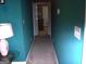 A carpeted hallway with blue-painted walls leads to multiple rooms in the house at 225 Long Creek Dr, Covington, GA 30016