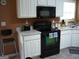 Kitchen with white cabinets and black appliances at 225 Long Creek Dr, Covington, GA 30016