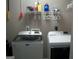 Functional laundry room with modern washer and dryer, plus wall-mounted storage shelf at 225 Long Creek Dr, Covington, GA 30016