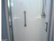 A clean white shower with a grab bar, shower head, and handle at 225 Long Creek Dr, Covington, GA 30016