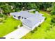 Aerial view of home with spacious lawn and an attached garage, surrounded by mature shade trees at 65 Pine Haven Ct, Carrollton, GA 30116