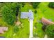 Aerial view of home with a sprawling lawn, an attached garage, and surrounded by mature shade trees at 65 Pine Haven Ct, Carrollton, GA 30116