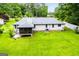 Spacious backyard featuring a screened porch, lush green grass, and mature trees at 65 Pine Haven Ct, Carrollton, GA 30116