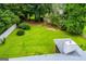 View of a large backyard bordered by trees with well-maintained lawn and partial house view at 65 Pine Haven Ct, Carrollton, GA 30116