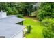 Aerial view showcasing a backyard and house with a well-kept lawn bordered by mature trees at 65 Pine Haven Ct, Carrollton, GA 30116