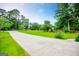 Long concrete driveway with lush green lawn and trees along the side at 65 Pine Haven Ct, Carrollton, GA 30116