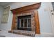 Classic brick fireplace with wooden mantel and glass doors at 65 Pine Haven Ct, Carrollton, GA 30116